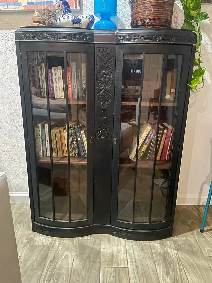 An elegant, vintage dark wood display cabinet with glass doors, a jewel among thrift store finds