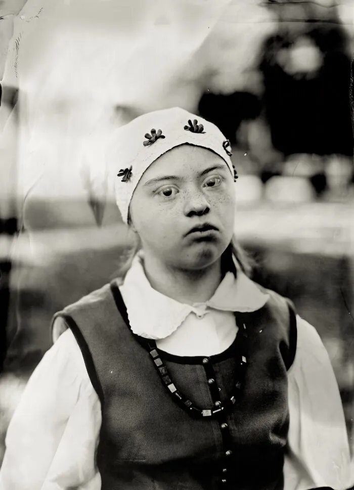 Black and white analog film portrait of young woman in folk costume