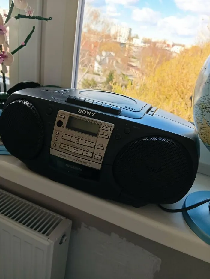 Sony boombox CD player on a window sill showing nostalgic pics of early 2000s technology