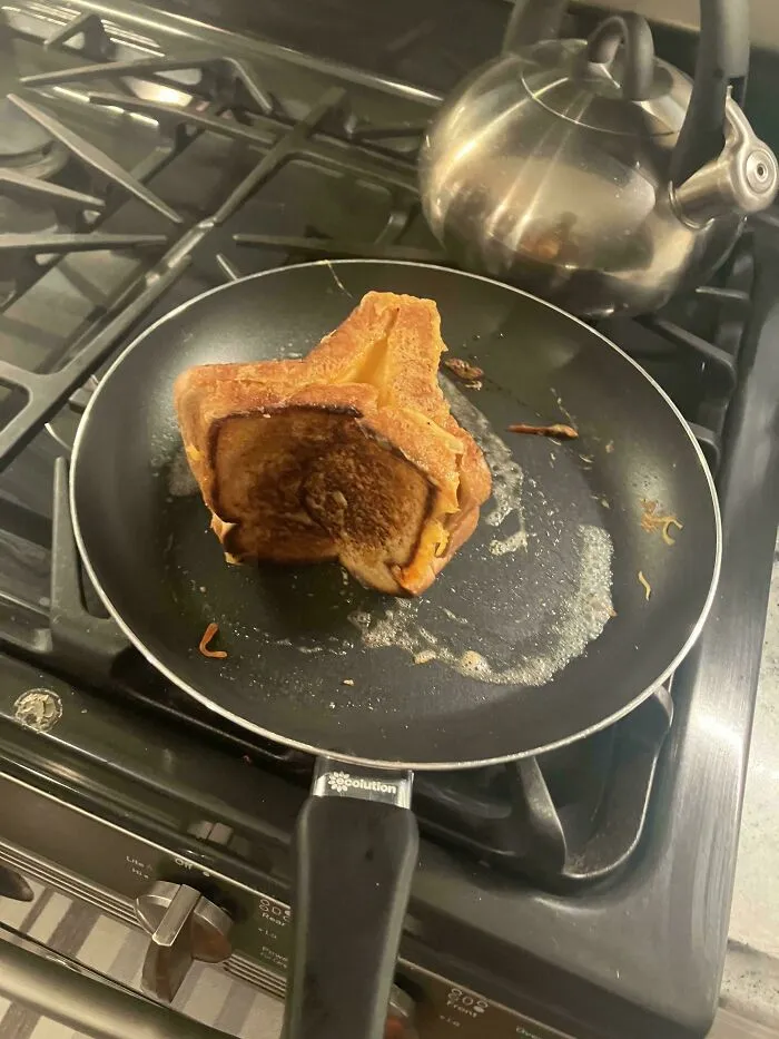 Toasted sandwich folded awkwardly in a frying pan, representing questionable food combos.
