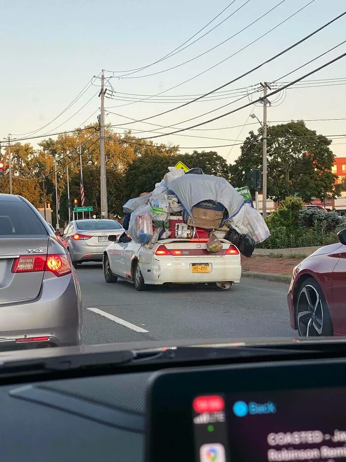Car overloaded with bulky items stacked high causing a moving fail on the street