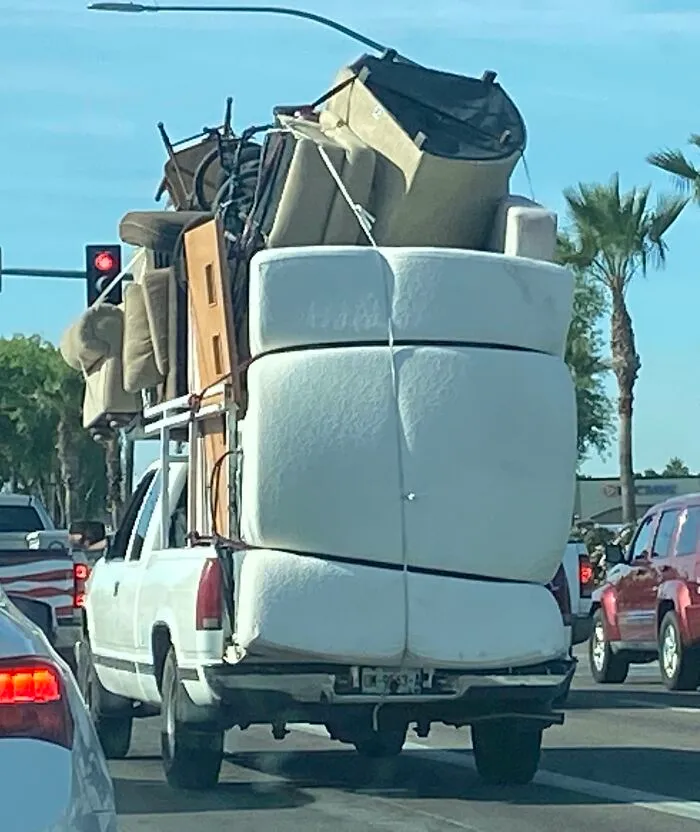 Pickup truck overloaded with bulky furniture causing moving fail