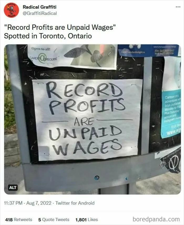 A sign on a bulletin board reads Record Profits are Unpaid Wages, highlighting disturbing levels of USA dystopia.