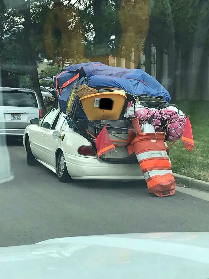 Car overloaded with items and traffic cones moving fails