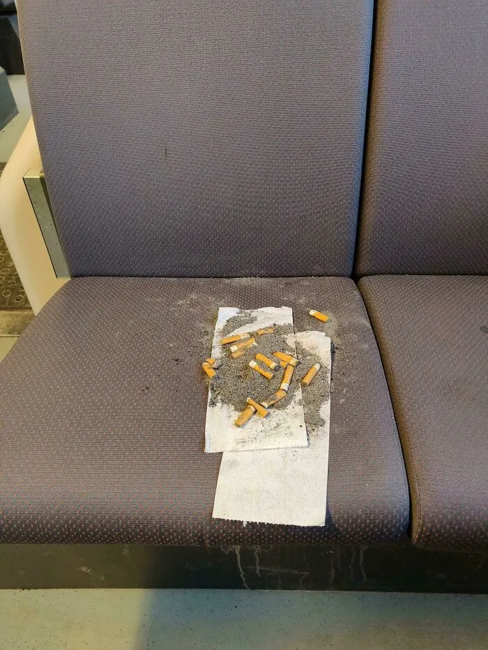 Cigarette butts and ash left on a seat, illustrating dirty public transport interactions