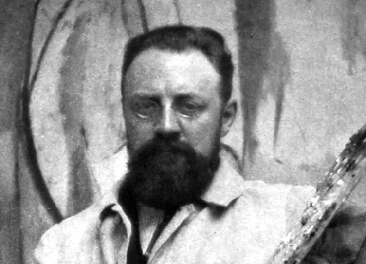 Vintage black and white photograph of artist Henri Matisse with a dark beard and glasses looking forward