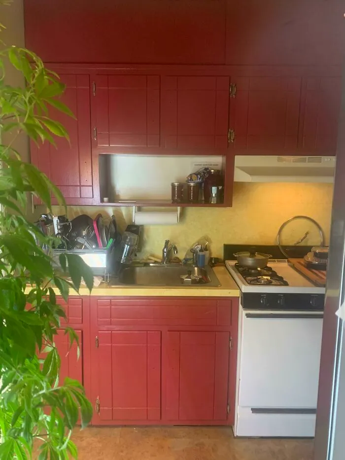 Red painted wooden kitchen cabinets and a sink area, highlighting colorful DIY home upgrades.