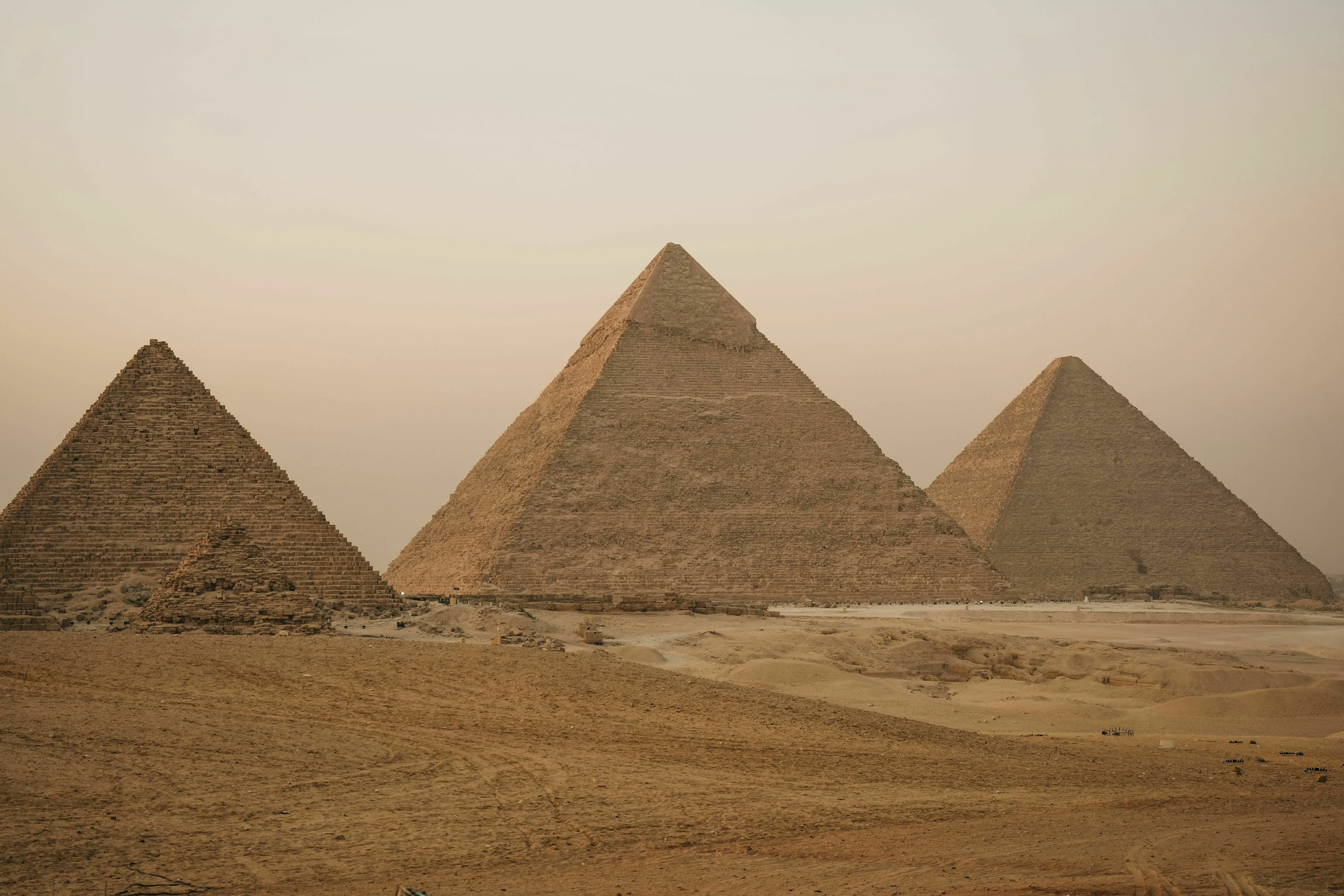 The ancient pyramids of Giza under a warm, hazy sky, perfect for a country with pyramids themed trivia.