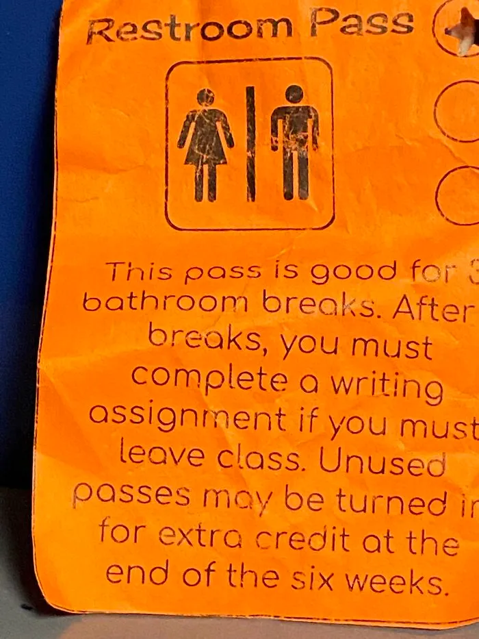 An orange school bathroom restroom pass with strict rules, showing how teachers manage their classrooms.