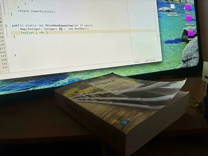 A Java programming textbook on a desk in front of a computer, relating to teachers who took their jobs seriously
