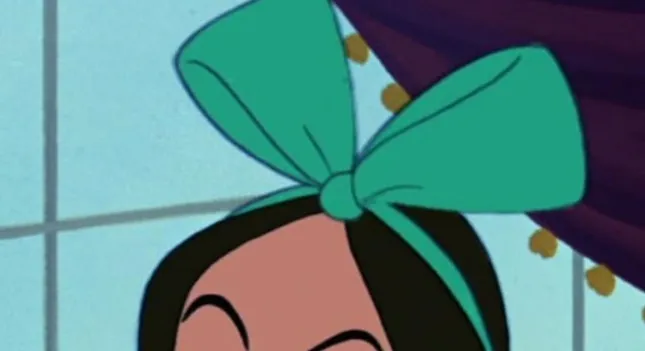 An extreme zoom-in on a Disney side character wearing a large teal bow in her dark hair.