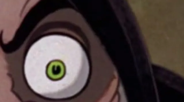 Extreme zoom-in of a wide green eye and dark eyebrow to guess the Disney character.
