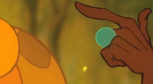 Close-up of a brown hand holding a small green sphere, a clue to guess the Disney character.