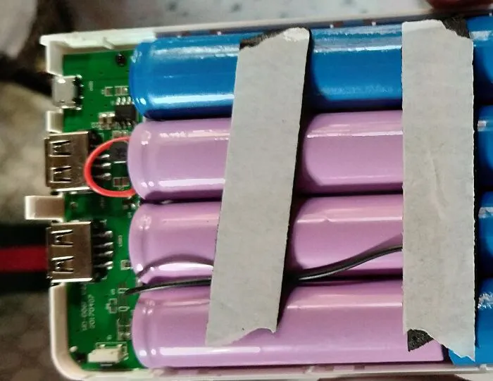 A power bank opened to show batteries taped together, a terrible product design safety hazard