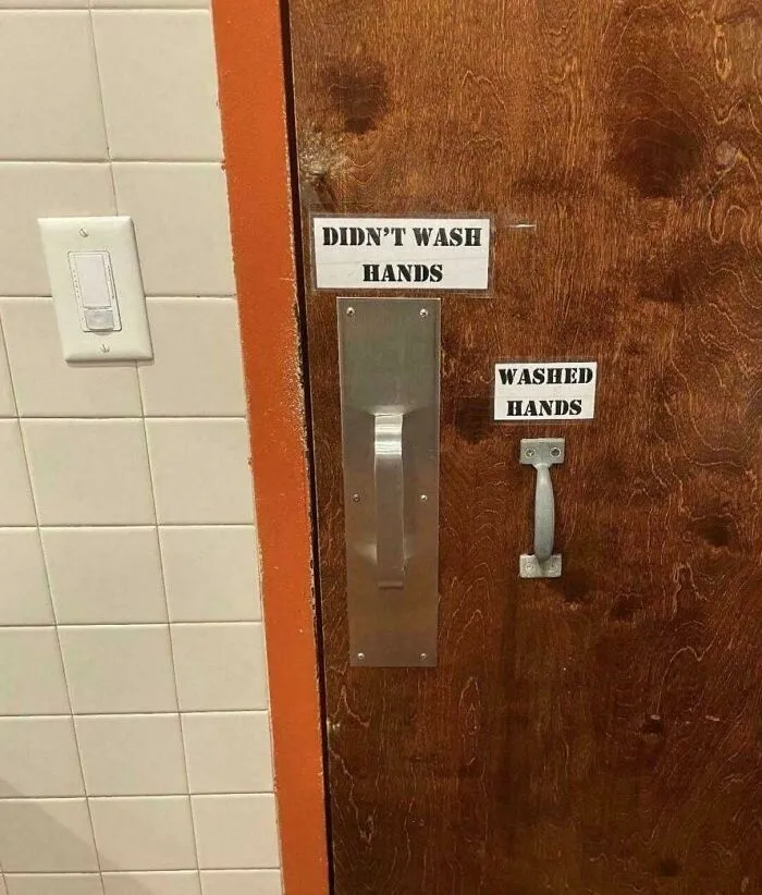 Bathroom door with handles labeled for washed and unwashed hands