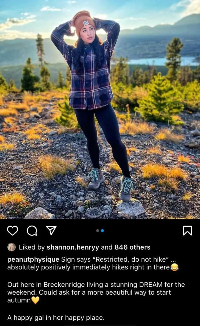 A woman posing outdoors in a restricted hiking area, exemplifying main character lives behavior.