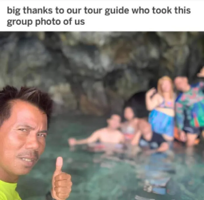 A tour guide taking a selfie with thumbs up while the tour group is blurry in the background.