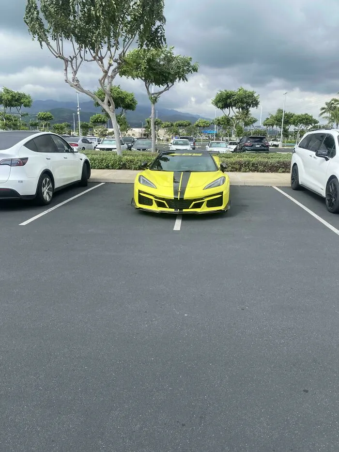 Yellow sports car parked across two parking spots, a classic example of living main character lives.