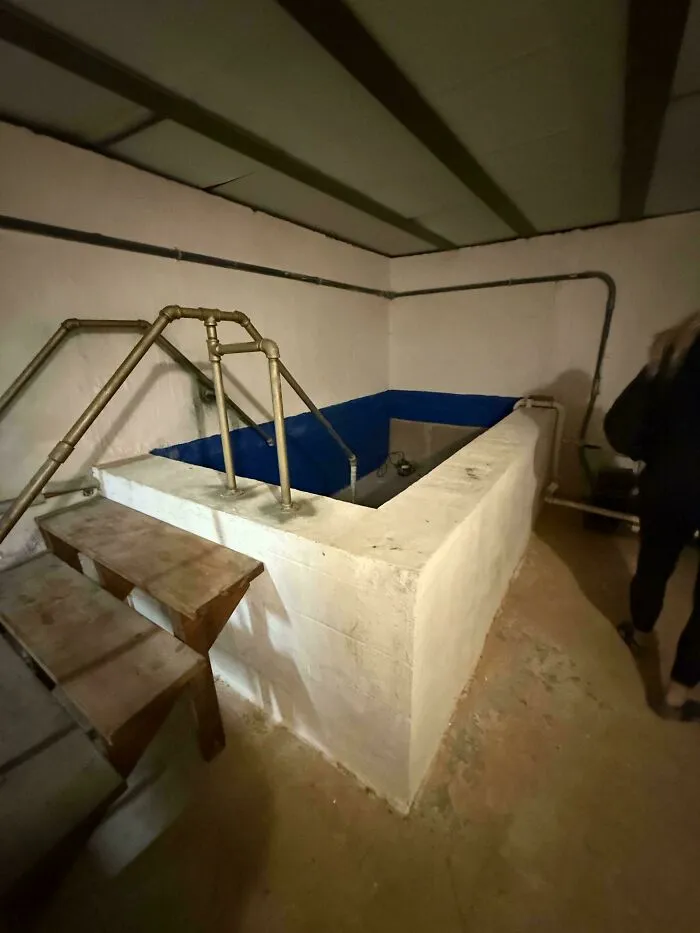 An indoor swimming pool resembling a concrete tub in a basement, a strange vision for houses with bad designs.