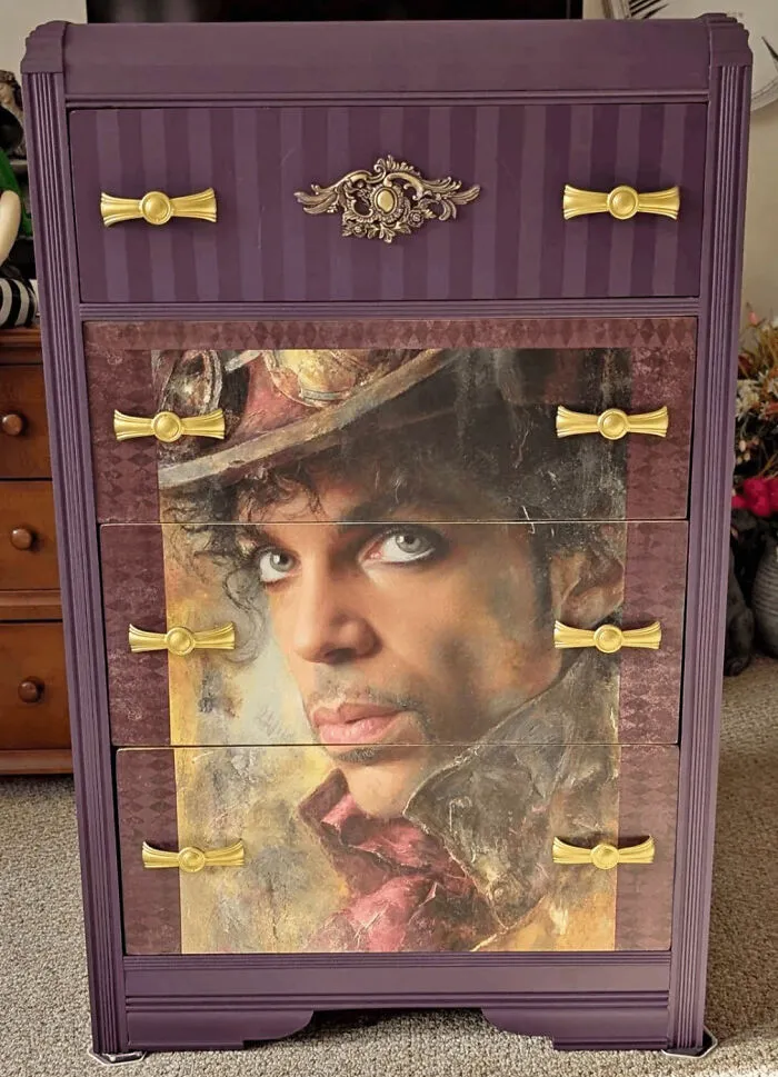 A purple dresser featuring a large portrait of the musician Prince showing a big vision