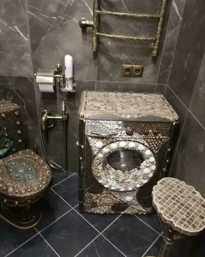 Ornately decorated washing machine with sea shells in an unusual bathroom with a big vision