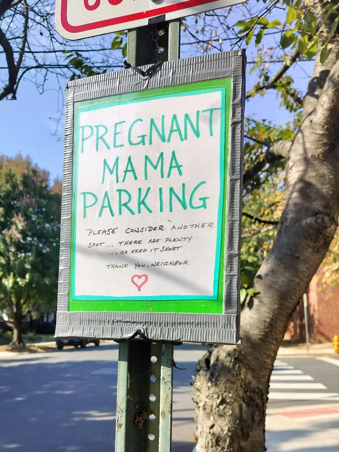 A self-appointed main character puts up a homemade Pregnant Mama Parking sign on a public street post.