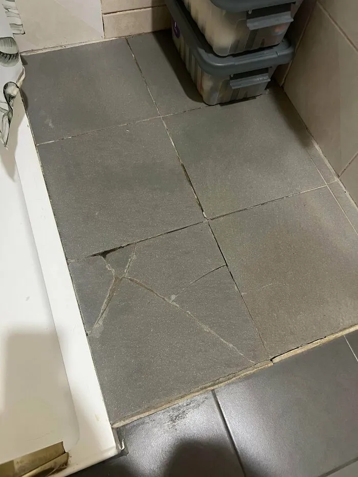 Cracked and broken floor tiles in a bathroom, showing a disappointing renting and booking experience.