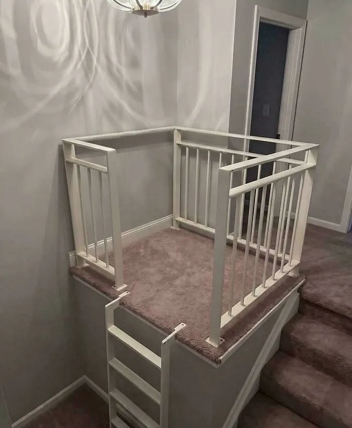 An awkward carpeted landing platform with a ladder next to a staircase, showing bad houses layouts.