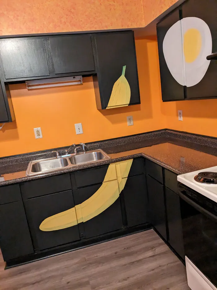 Kitchen cabinets painted with giant banana and egg graphics, showcasing weird houses interior design.