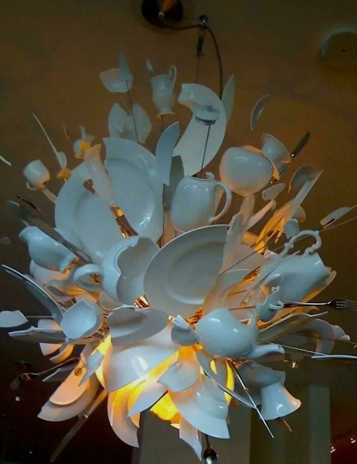A chandelier made of broken plates and teacups, illustrating houses with bad design choices.
