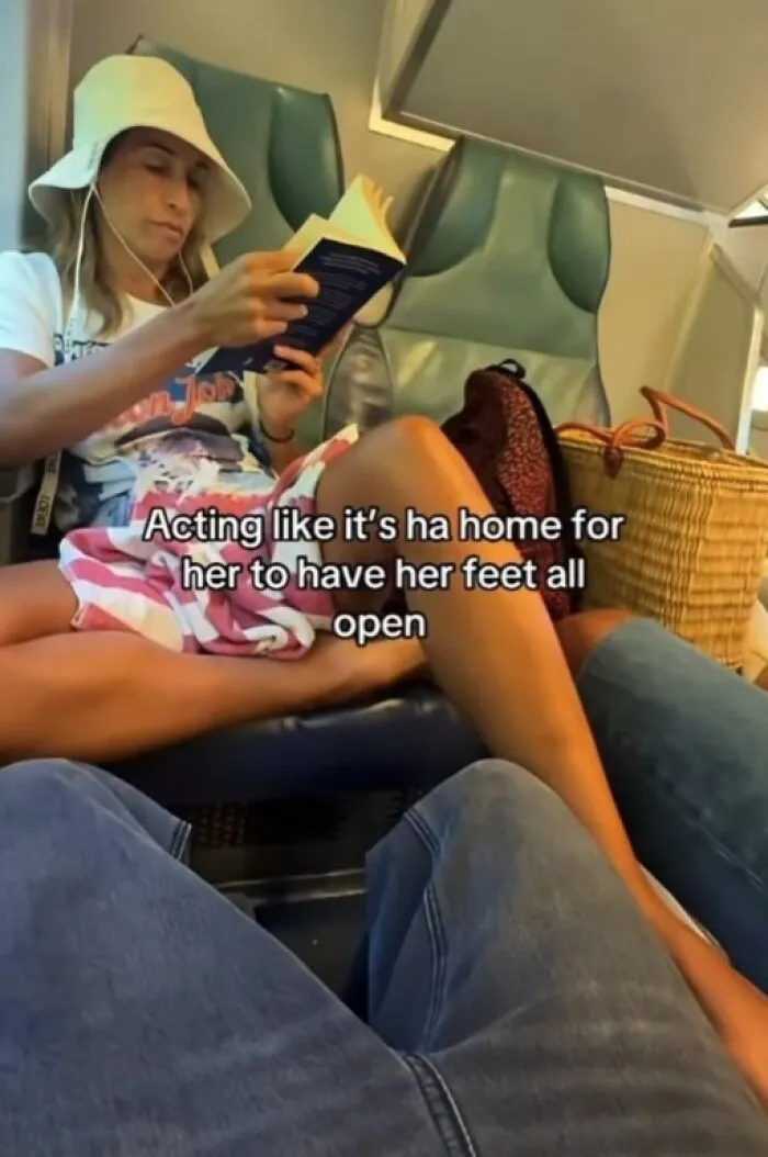 Woman with feet on someone else's space in public transit, illustrating main character lives attitude.