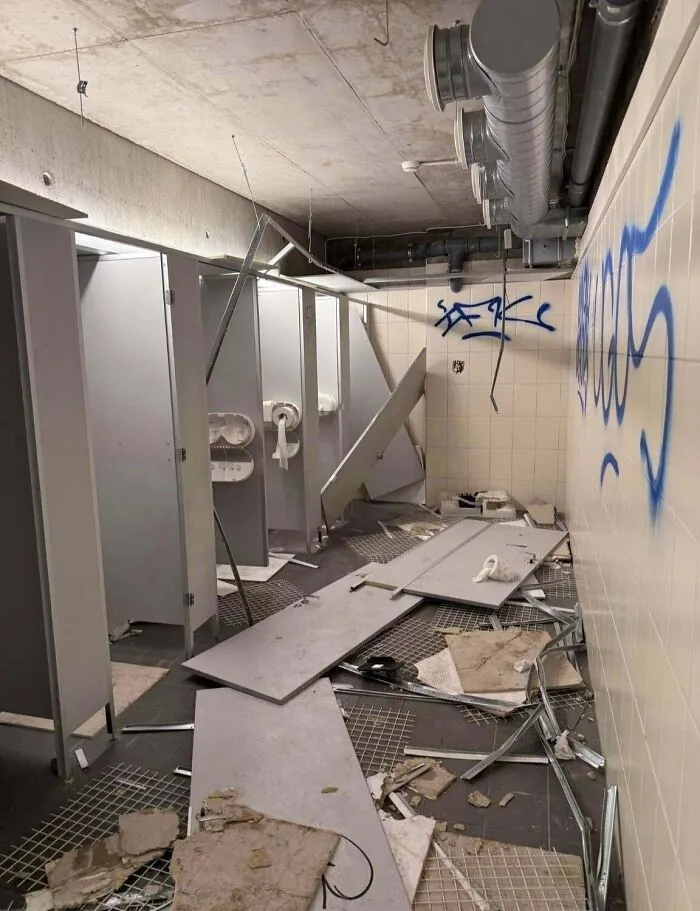 A completely destroyed public restroom representing the chaotic actions of main character individuals