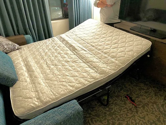 A sofa bed mattress folded at an awkward angle in a house with questionable design choices.