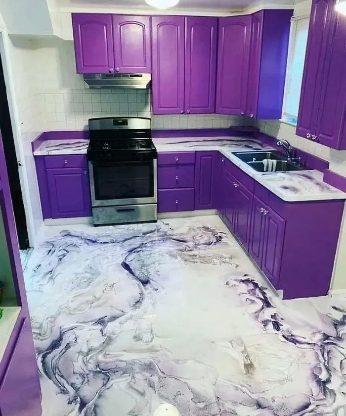 A modern kitchen featuring vibrant purple cabinets and an epoxy floor with swirling white and purple patterns.