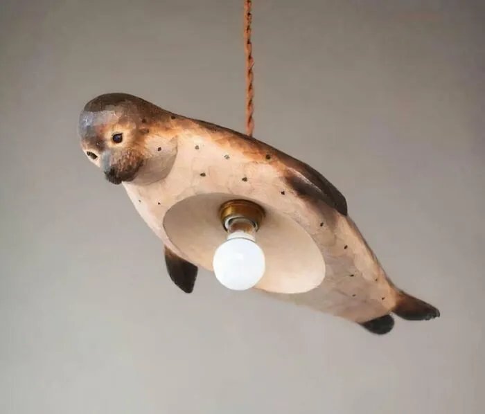 Unique houses decor showing a hand-carved wooden seal pendant light hanging from a cord