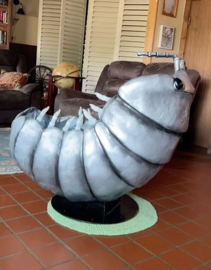 Large metallic grey roly poly bug shaped chair in living room houses decor.