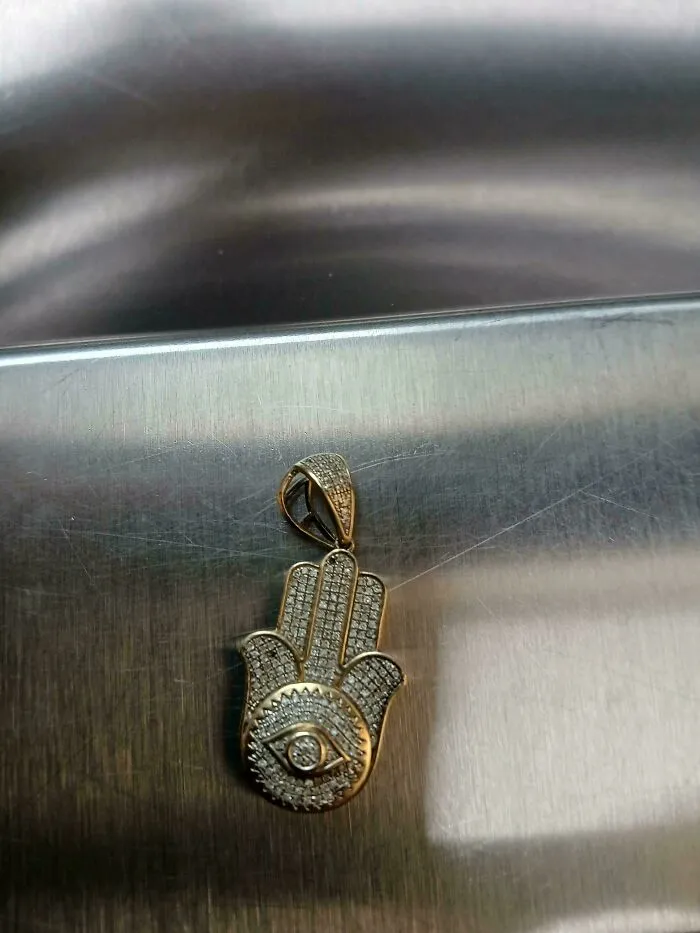 Gold hamsa hand pendant found while dumpster diving