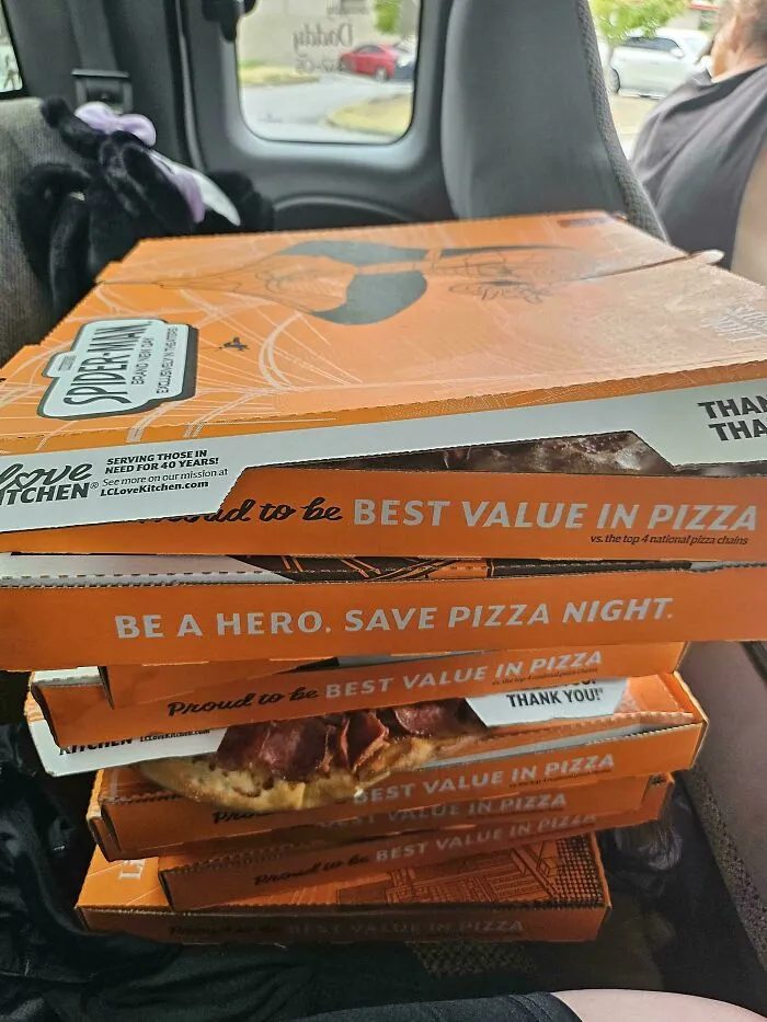 Stack of pizza boxes showing best value in pizza slogan as dumpster diving find