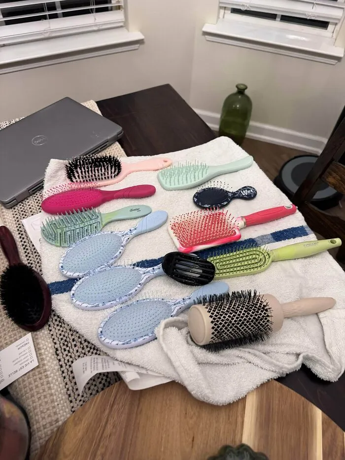 Various hairbrushes laid out on towel from dumpster diving finds