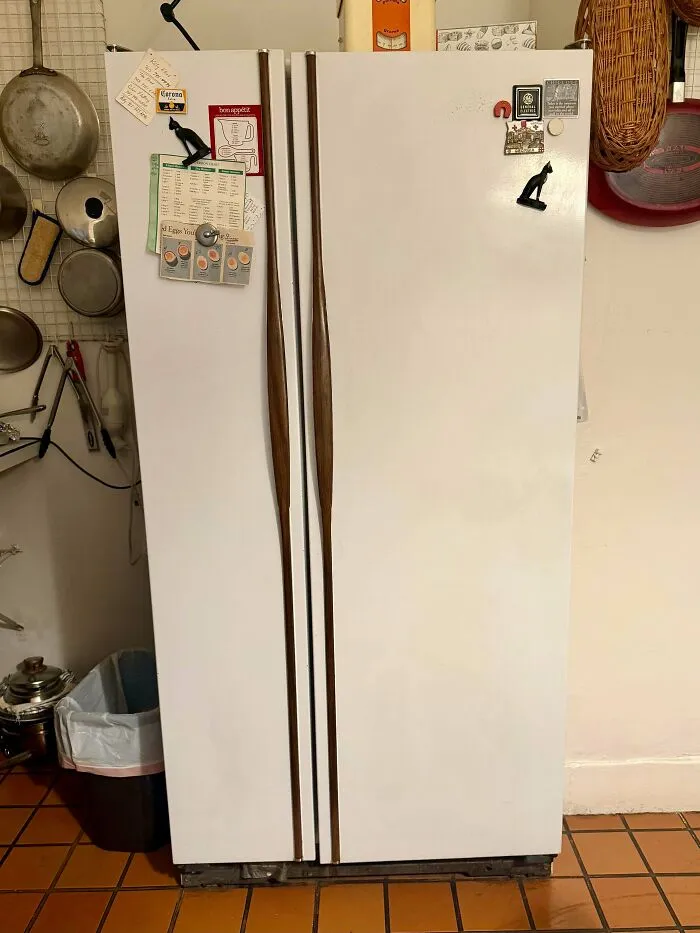 A white vintage refrigerator with wooden handles as an example of durable old products built to last.