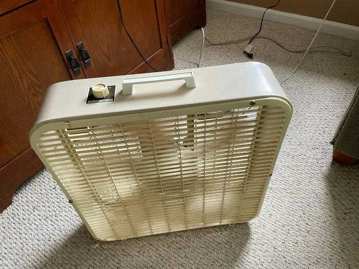 Classic beige portable box fan indoors, highlighting reliable old products that work after decades of daily use.
