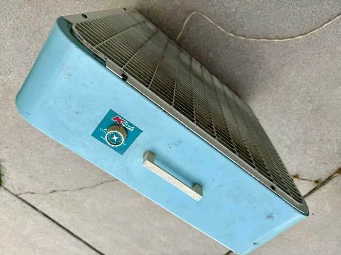 Retro blue Kmart box fan on concrete, featuring durable old products that continue working over decades of use.