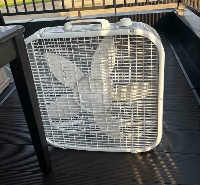 White Lasko portable box fan outdoors, showing durable old products still functioning after decades of daily use.