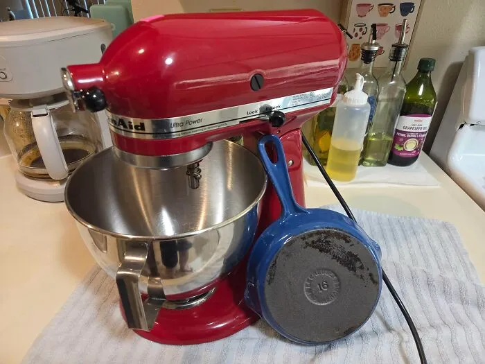 A red KitchenAid stand mixer and blue skillet on a counter, examples of reliable old products still in daily use.