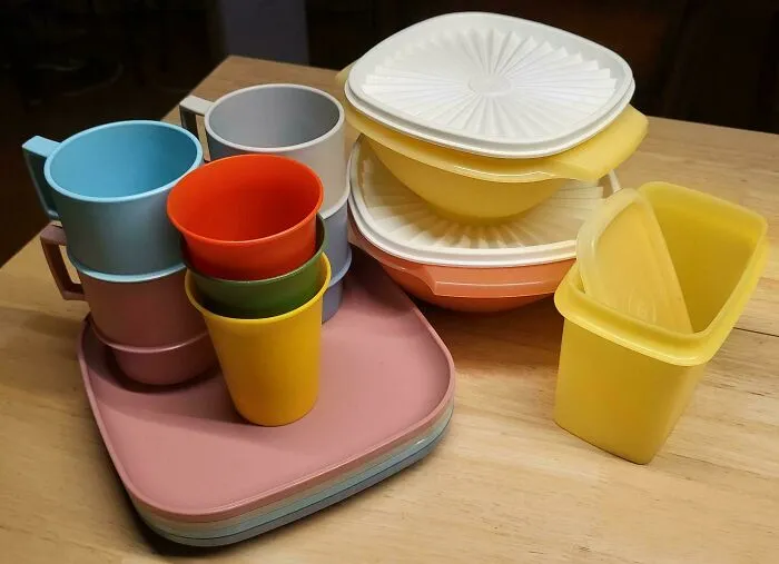 A colorful set of vintage plastic Tupperware cups, bowls, and plates illustrating functional old products.