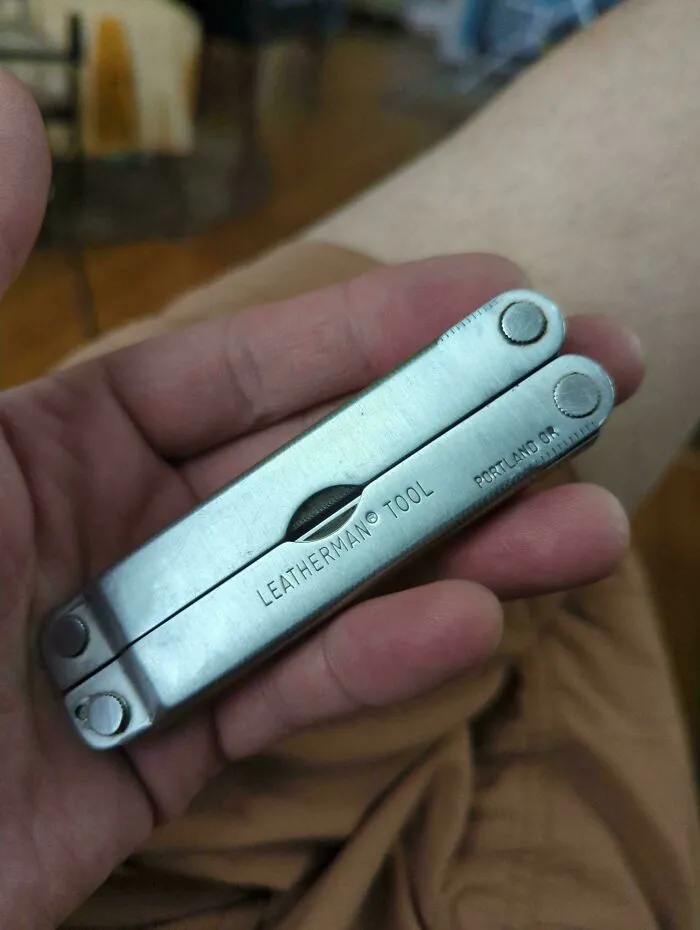 A classic metal Leatherman multi-tool held in a hand showing reliable old products for everyday utility.