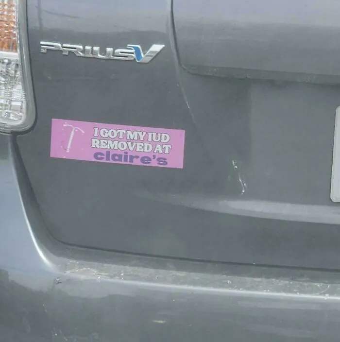 Humorous and wild bumper sticker on a grey vehicle rear end.