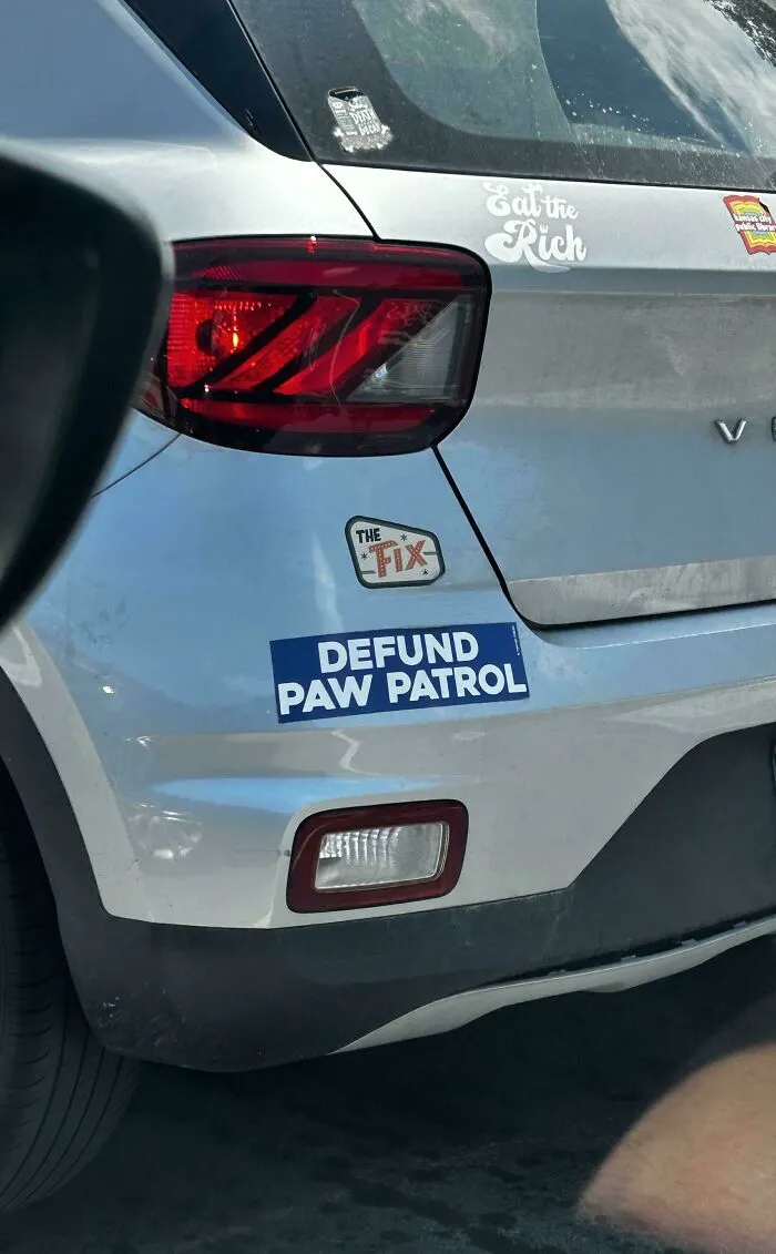 Wild bumper stickers reading Defund Paw Patrol on a silver car.