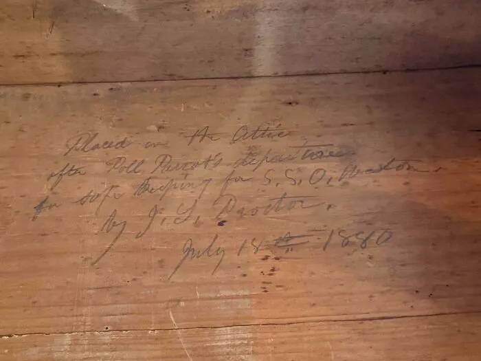 Handwritten note dated 1880 inside wooden box showing old treasures discovered by antique lovers.