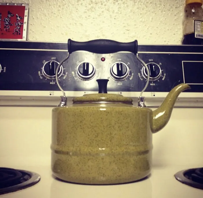 Teapot on stove knobs creating face illusion with eye confusing effect